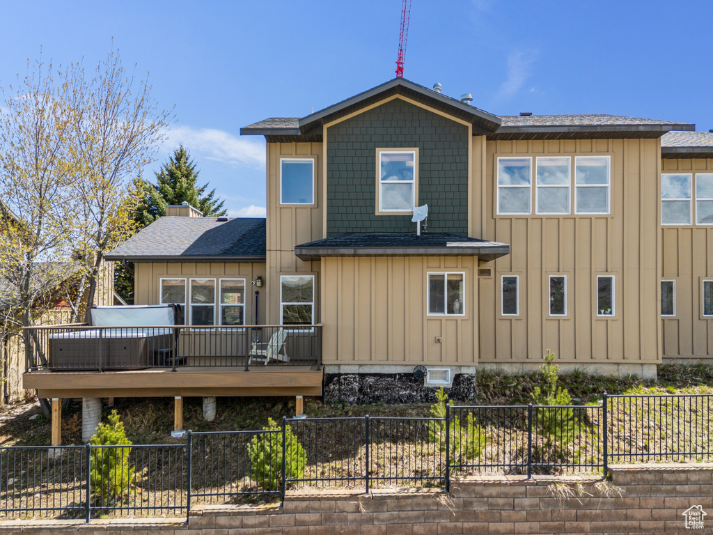 Back of house featuring a wooden deck, a fenced backyard, a shingled roof, and board and batten siding