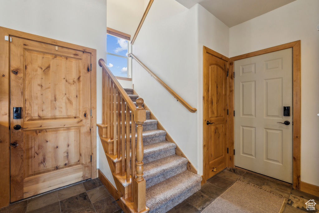 Entrance foyer featuring stairs and stone finish flooring