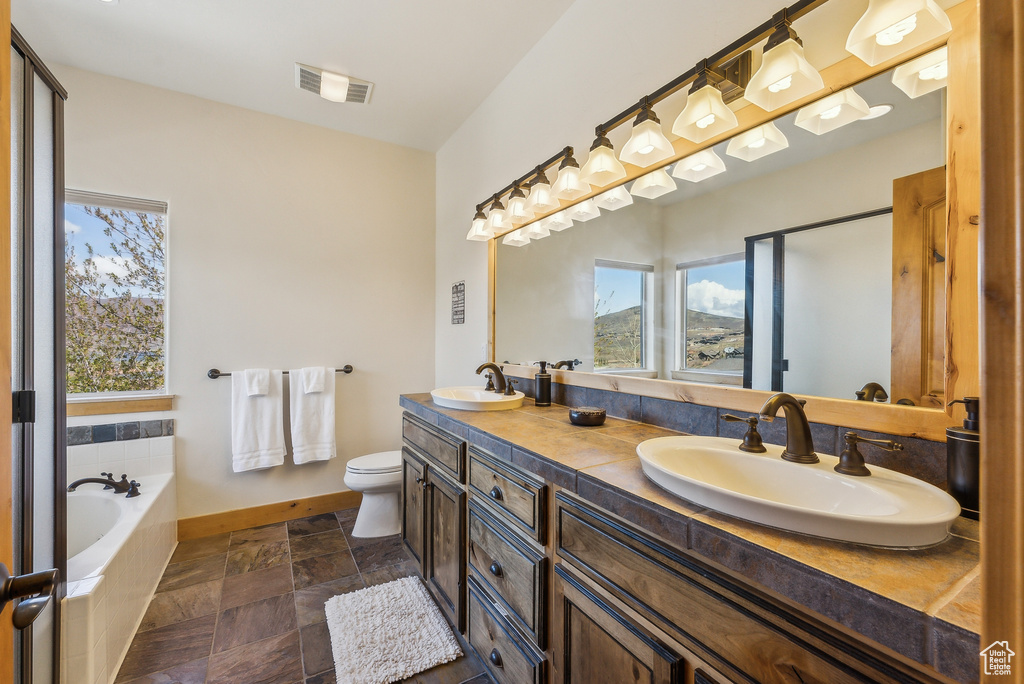Bathroom with visible vents, plenty of natural light, and a sink