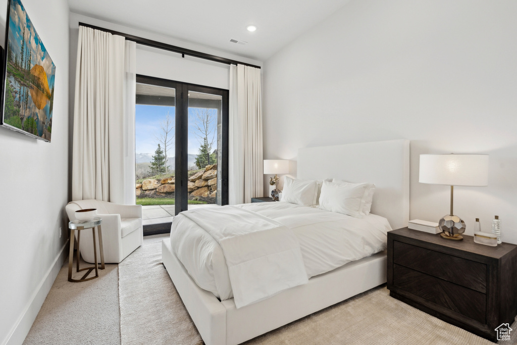 Bedroom with access to exterior, visible vents, light colored carpet, and baseboards