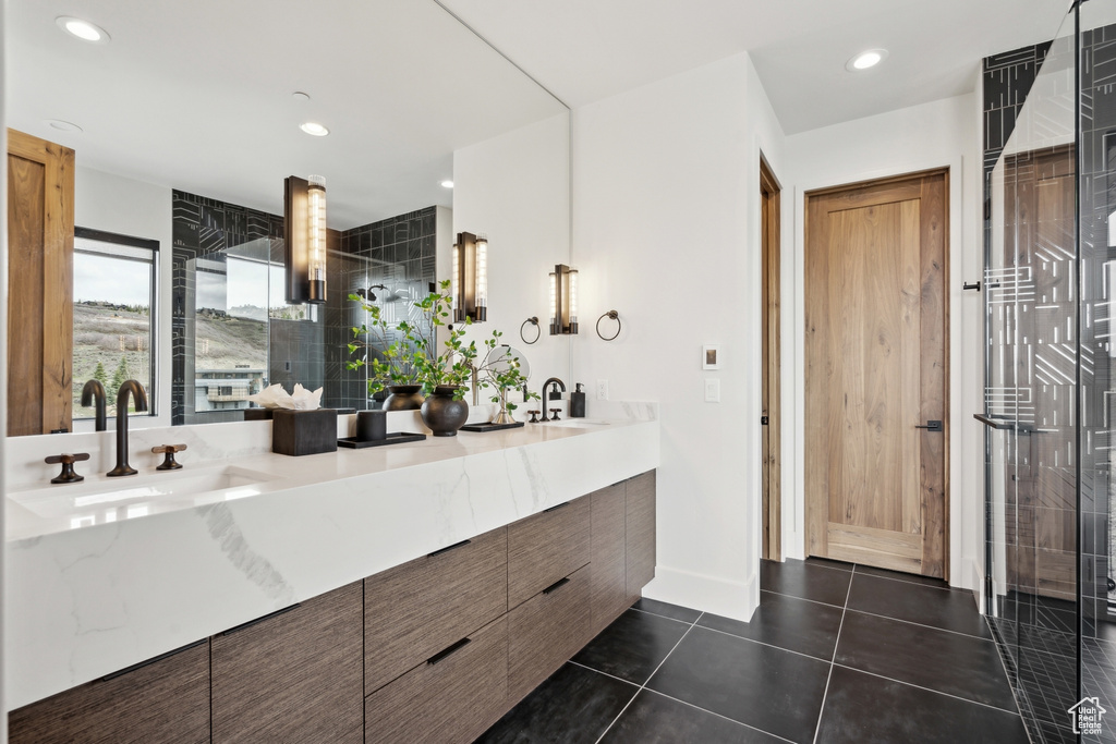 Bathroom featuring recessed lighting, double vanity, a sink, and tile patterned floors