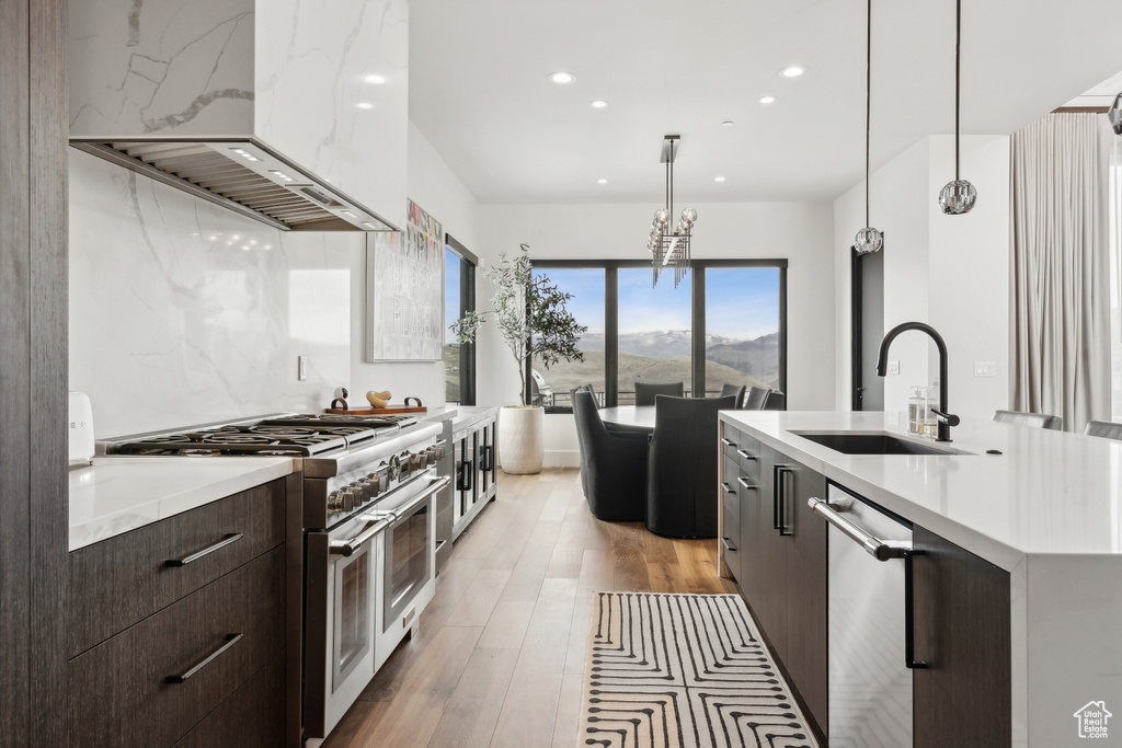 Kitchen with recessed lighting, custom exhaust hood, stainless steel appliances, a sink, and modern cabinets