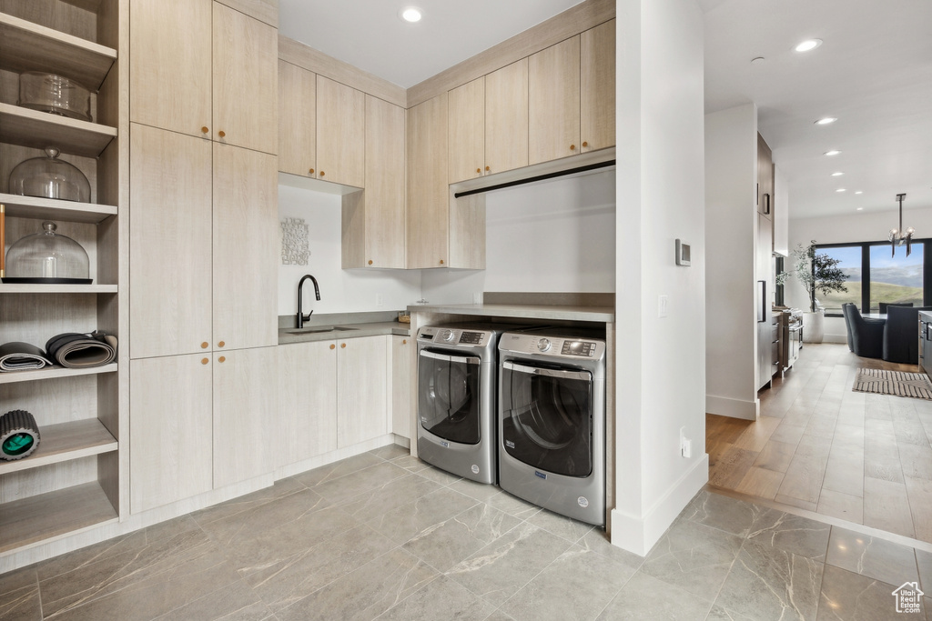 Laundry room featuring a sink, baseboards, washer and dryer, cabinet space, and marble finish floor