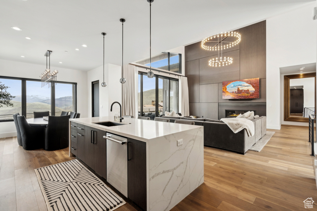 Kitchen with a notable chandelier, modern cabinets, light wood finished floors, and a sink