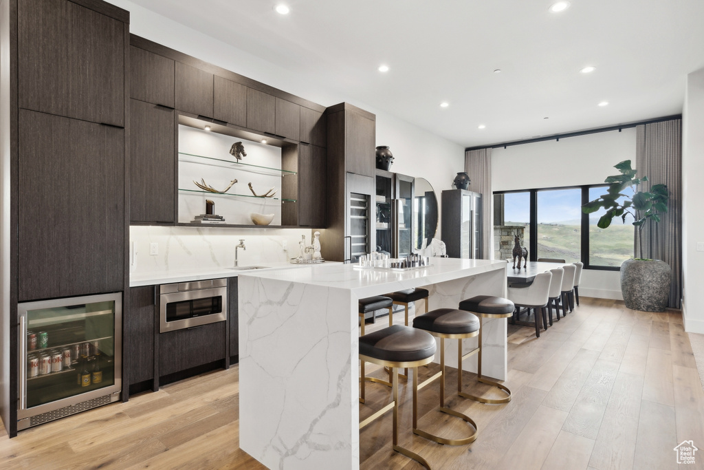 Kitchen with wine cooler, recessed lighting, a sink, and a breakfast bar