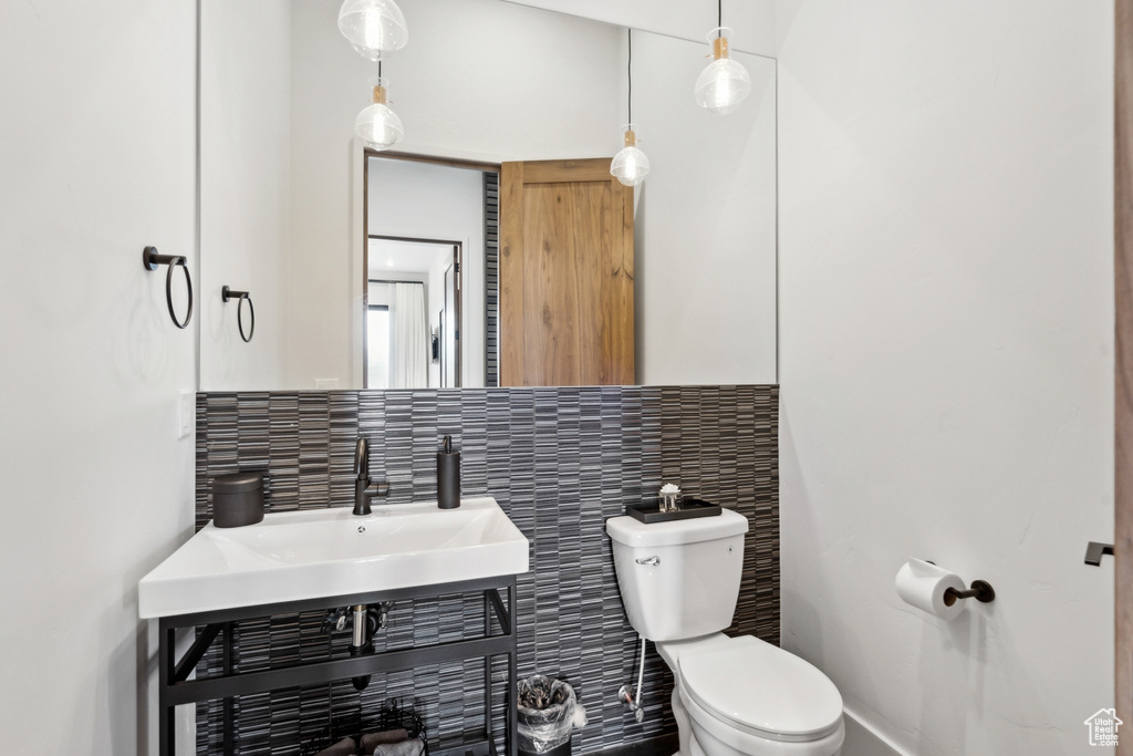 Half bathroom with toilet and decorative backsplash