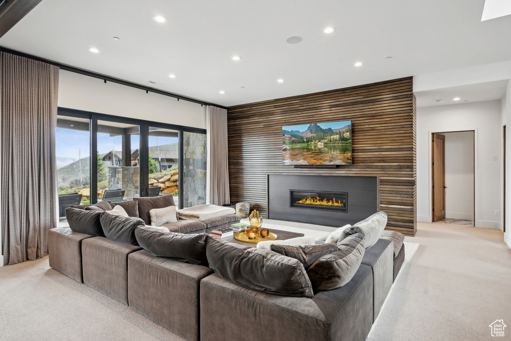 Living area featuring recessed lighting, light carpet, and a glass covered fireplace