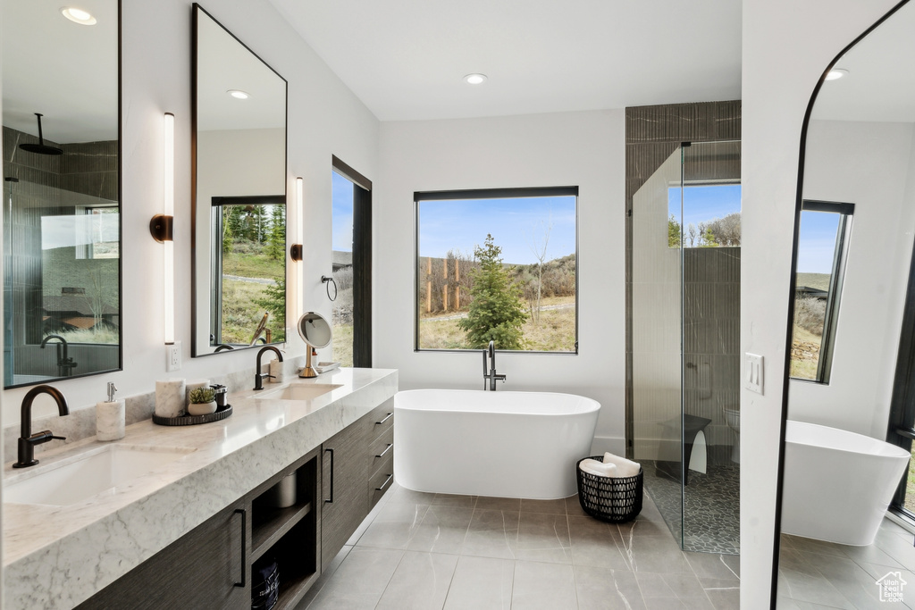 Full bathroom with a freestanding bath, double vanity, a sink, and a shower stall