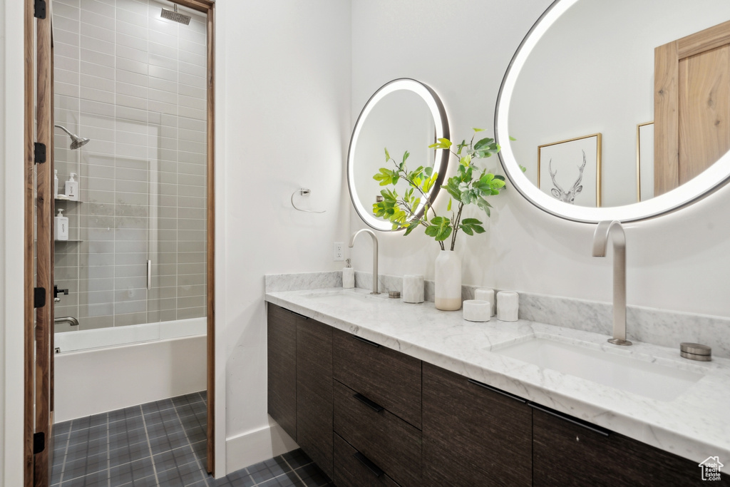 Bathroom with double vanity, tub / shower combination, and a sink