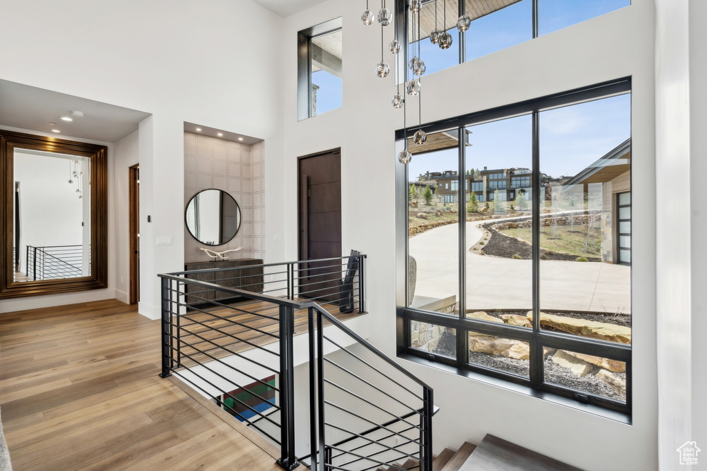 Stairs with a towering ceiling, wood finished floors, and baseboards