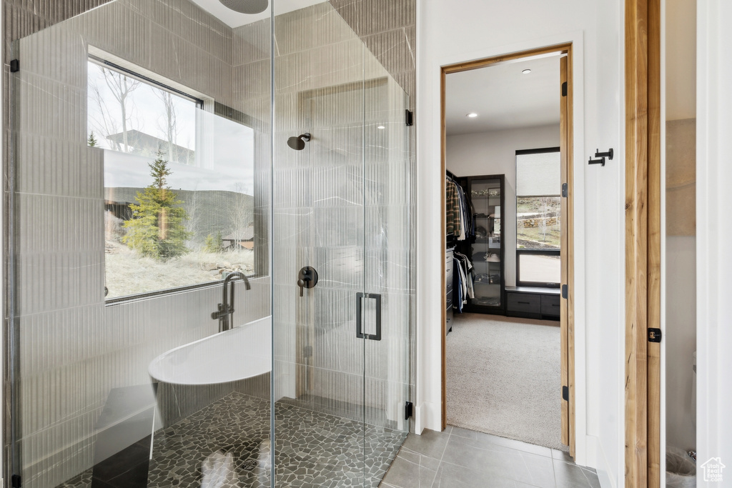 Full bath with a shower stall and tile patterned flooring