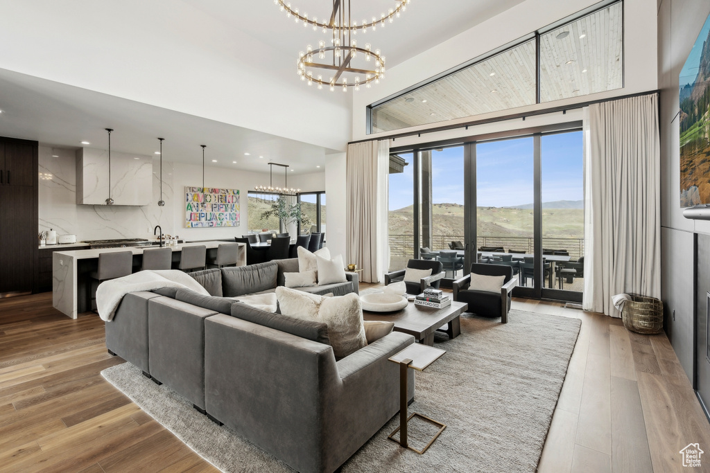 Living room with recessed lighting, a mountain view, a chandelier, and light wood-type flooring