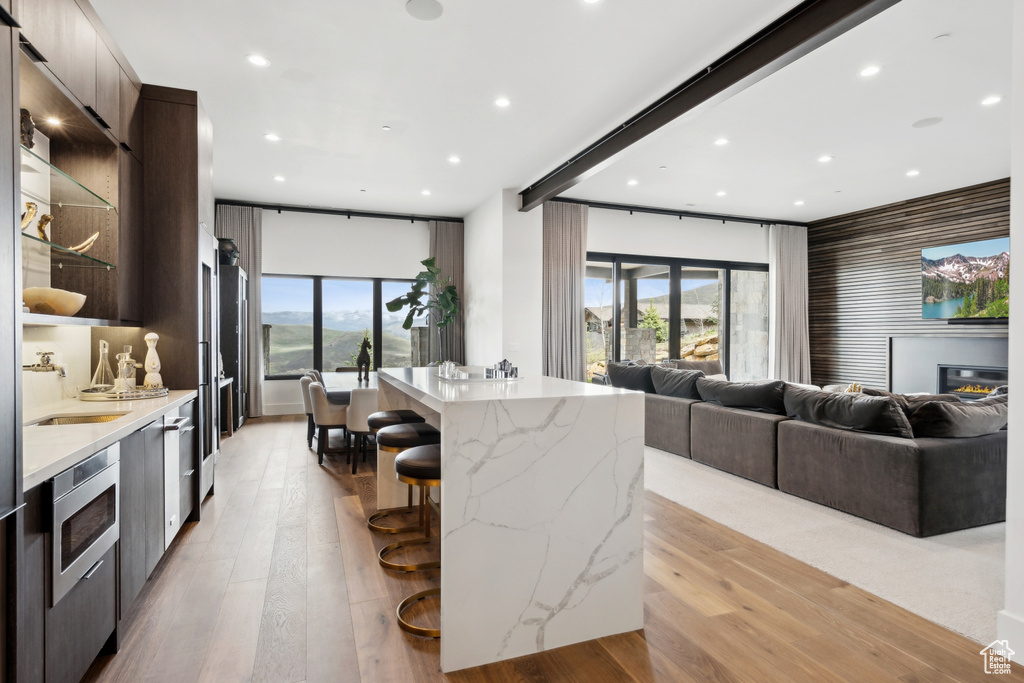 Kitchen featuring a sink, light wood-style floors, a kitchen bar, recessed lighting, and modern cabinets