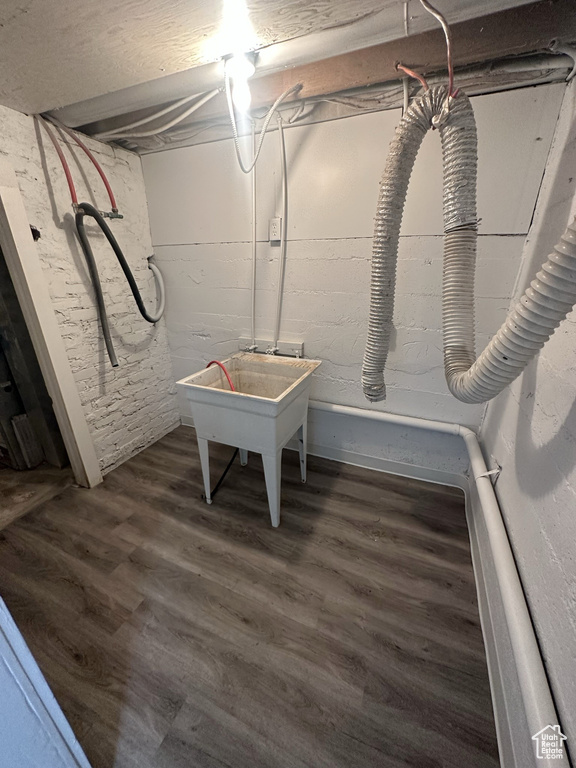 Unfinished below grade area with wood finished floors and a sink