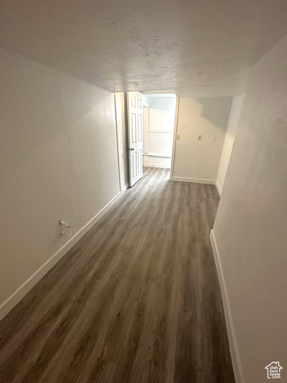 Interior space featuring baseboards and dark wood-style flooring