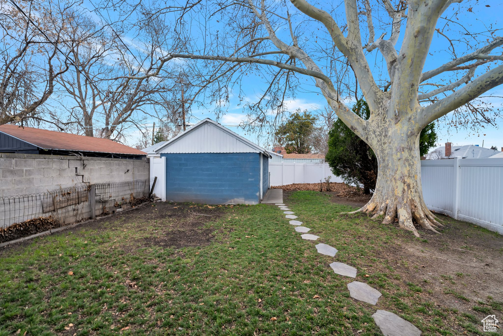 View of yard with a fenced backyard and an outbuilding