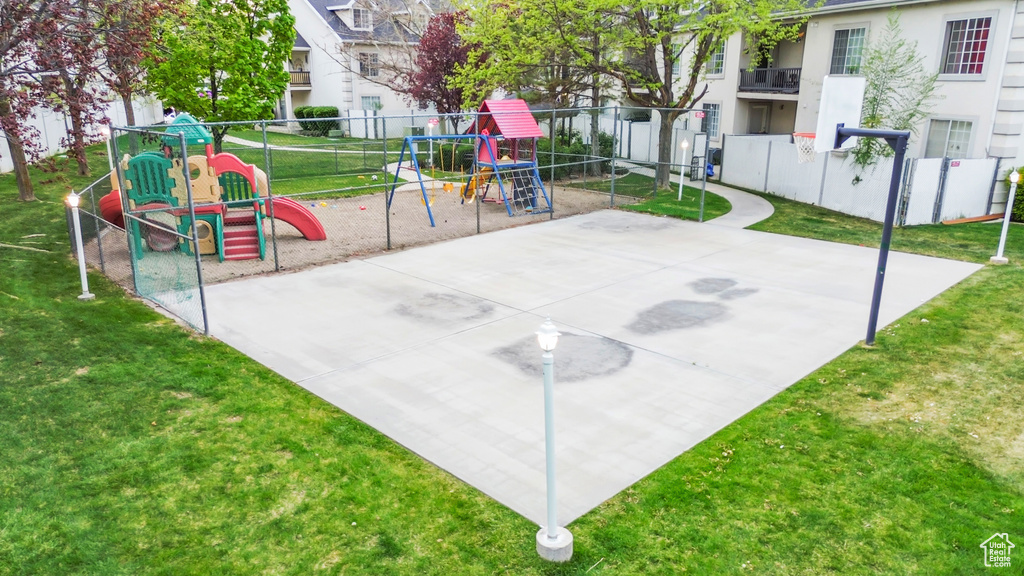 Exterior space with fence, playground community, and a lawn
