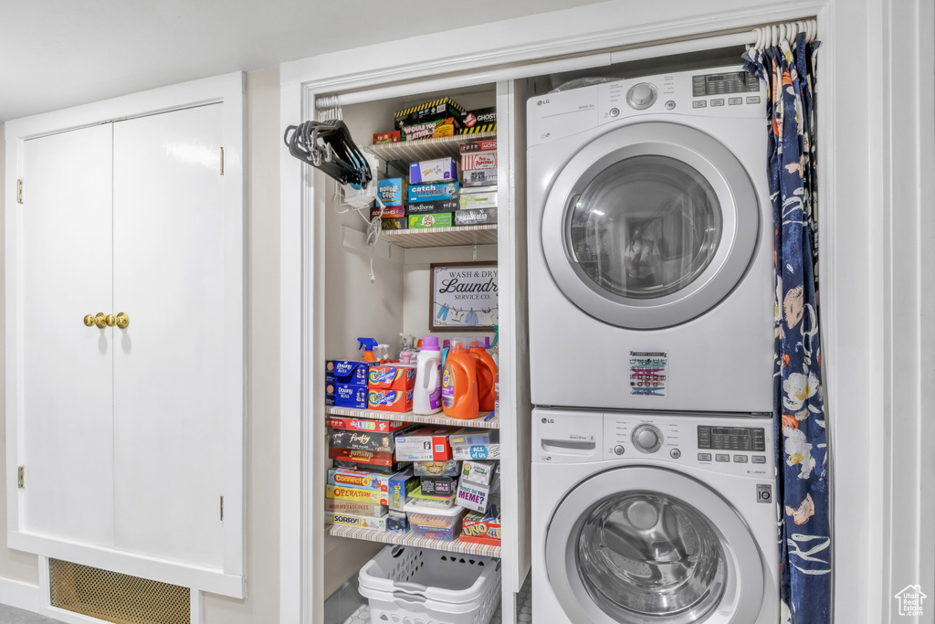 Washroom featuring stacked washer / dryer and laundry area