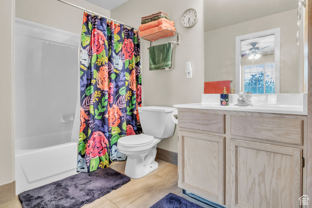 Full bath featuring toilet, shower / bath combination with curtain, vanity, a ceiling fan, and tile patterned flooring