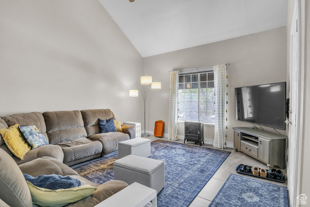 Tiled living area with baseboards and vaulted ceiling