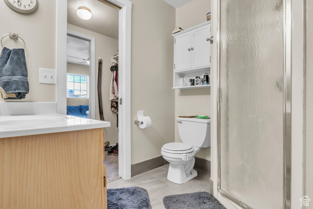 Full bathroom with tile patterned floors, a shower stall, toilet, vanity, and baseboards