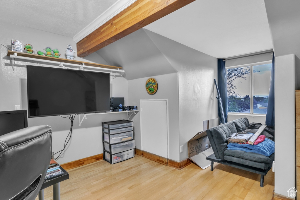 Home office with wood finished floors, vaulted ceiling, and baseboards