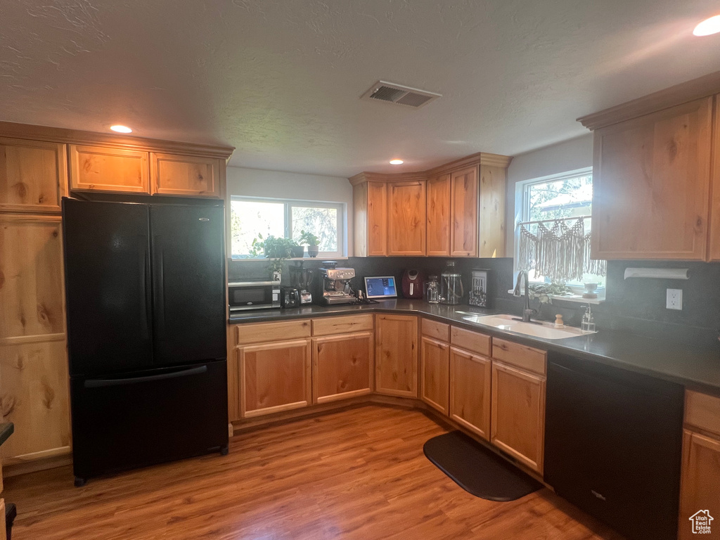Kitchen with visible vents, black appliances, a healthy amount of sunlight, and a sink