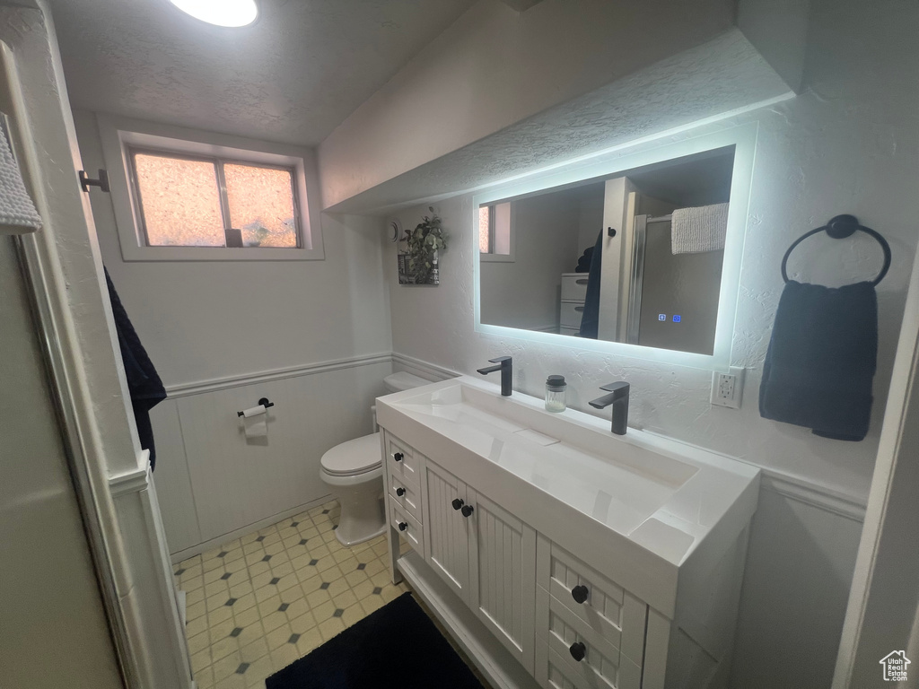 Full bath with toilet, a shower with shower door, tile patterned floors, and vanity