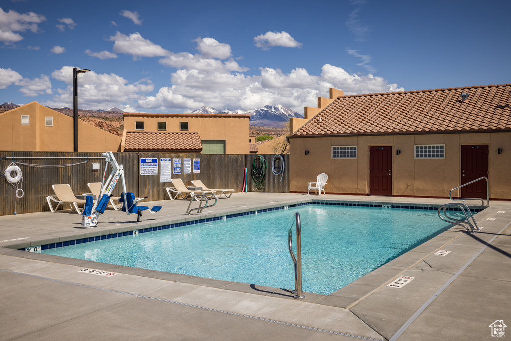 Pool featuring a patio area, a mountain view, and fence