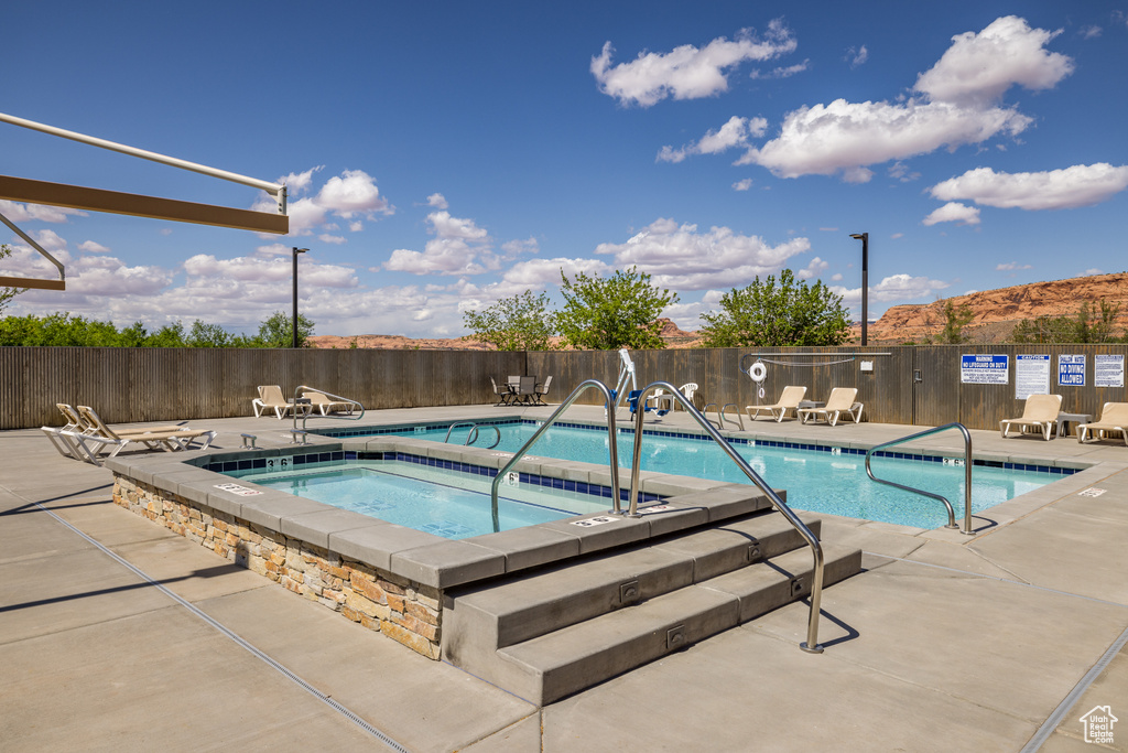 Pool featuring a patio area, a hot tub, and fence