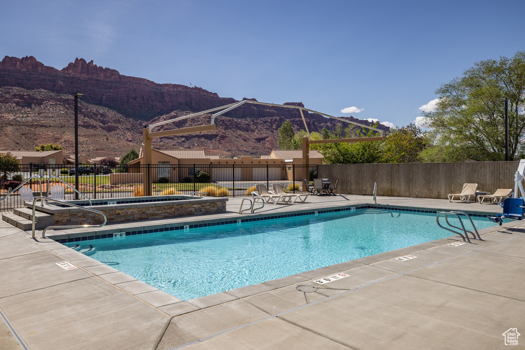 Pool featuring a patio area, a mountain view, and fence