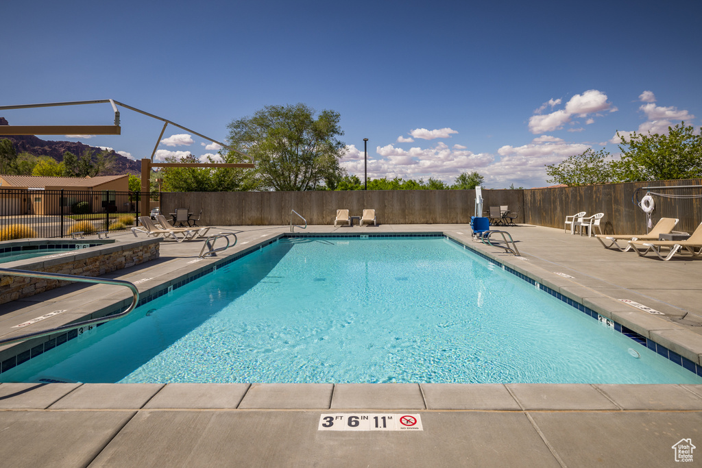 Community pool featuring a patio and fence