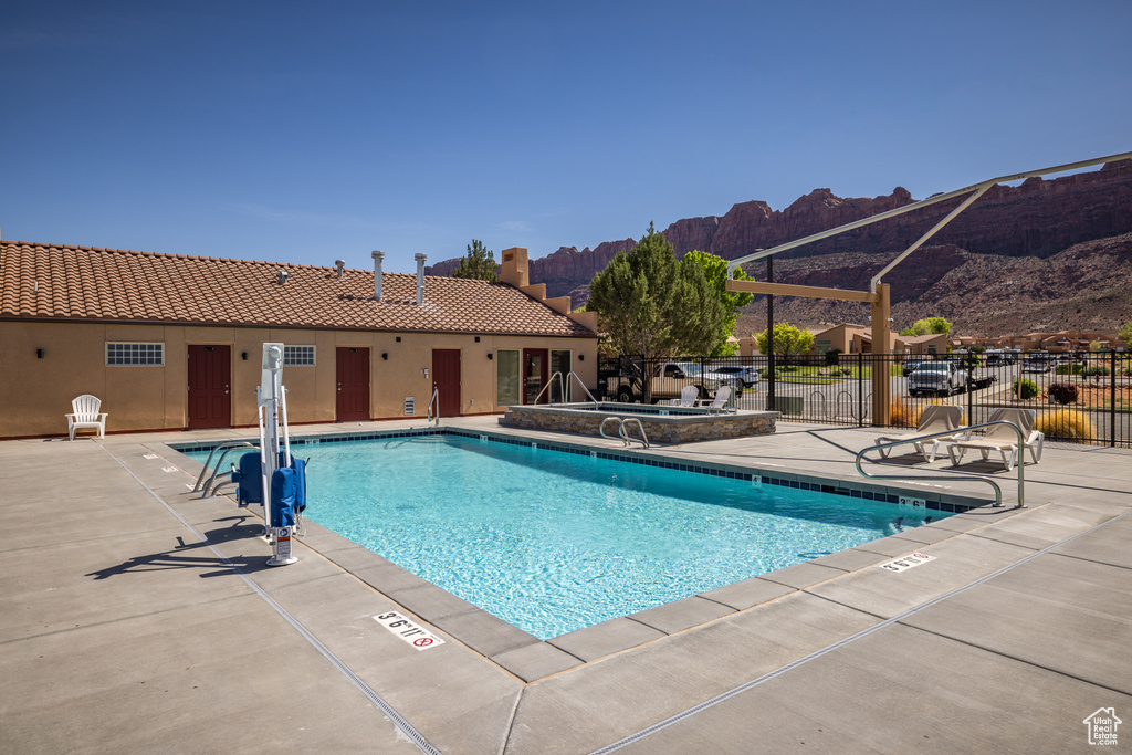 Community pool featuring fence, a mountain view, and a patio area