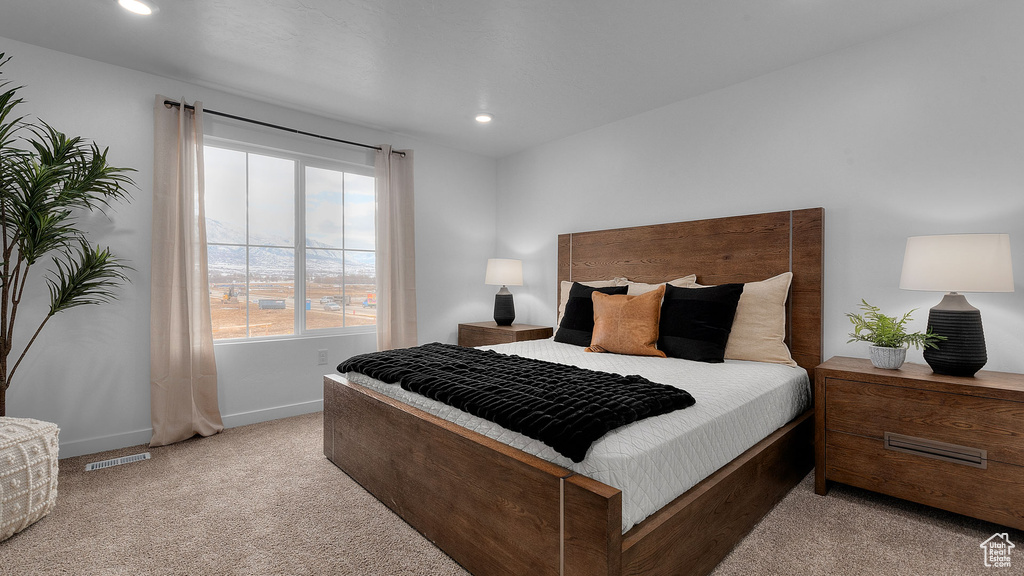 Carpeted bedroom with recessed lighting, visible vents, and baseboards