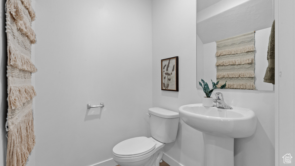 Half bathroom with toilet and baseboards