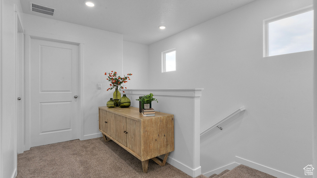 Hall featuring an upstairs landing, visible vents, baseboards, recessed lighting, and light carpet