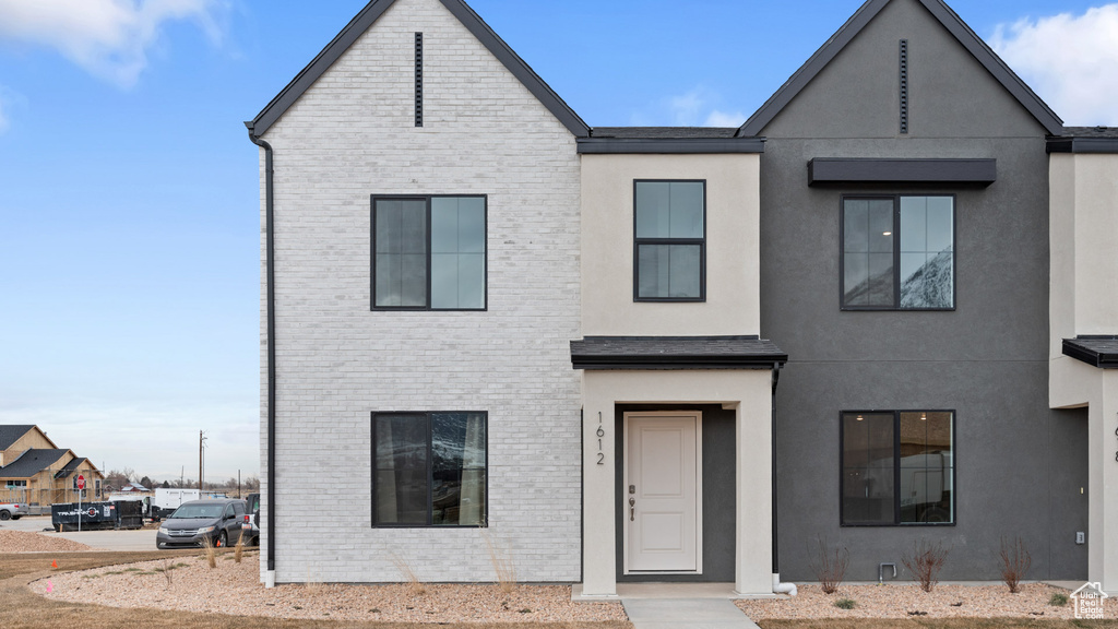 View of property with stucco siding and brick siding