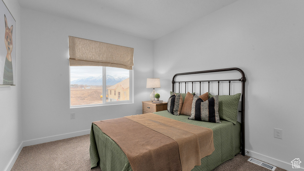 Carpeted bedroom featuring baseboards and visible vents