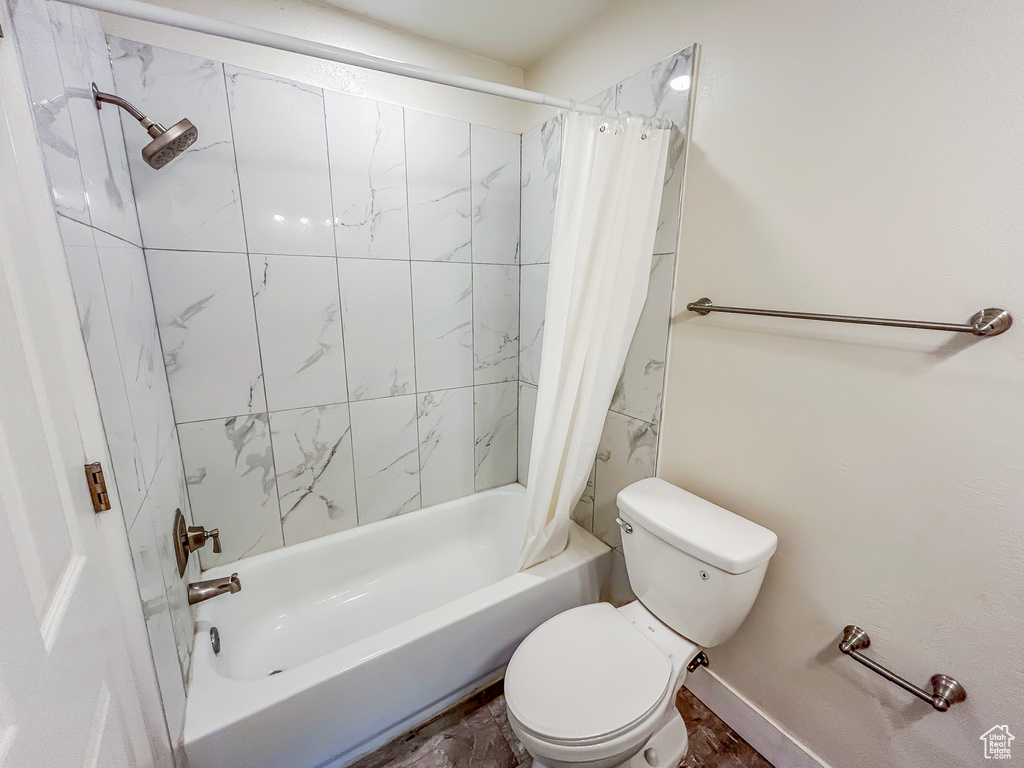 Bathroom featuring shower / bath combo and toilet