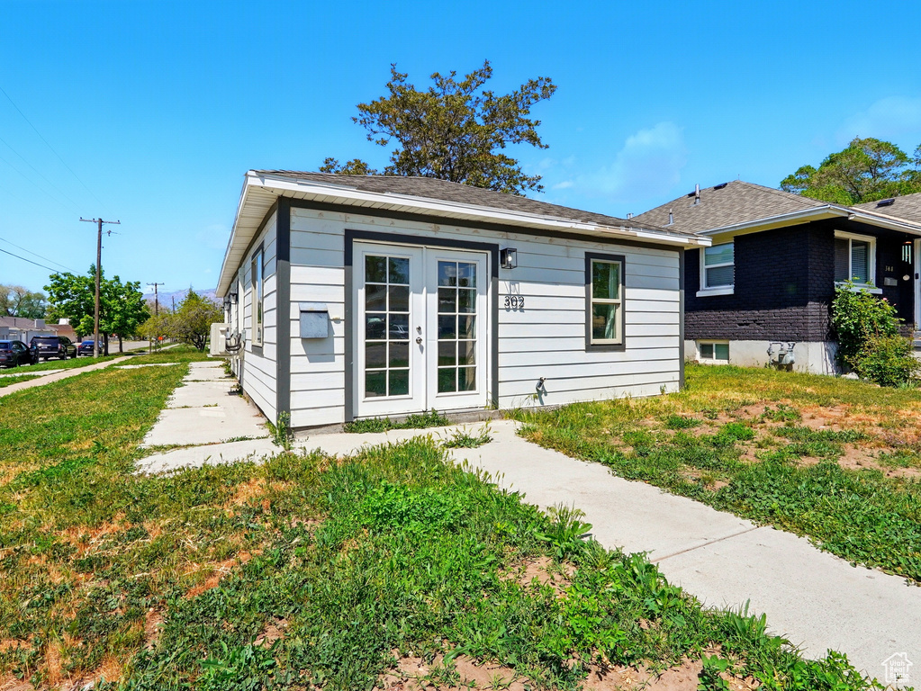 Back of property with french doors and a yard