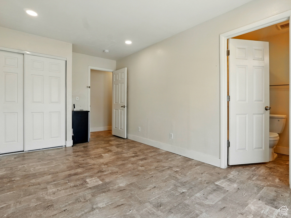 Unfurnished bedroom featuring wood finished floors, baseboards, recessed lighting, and a closet