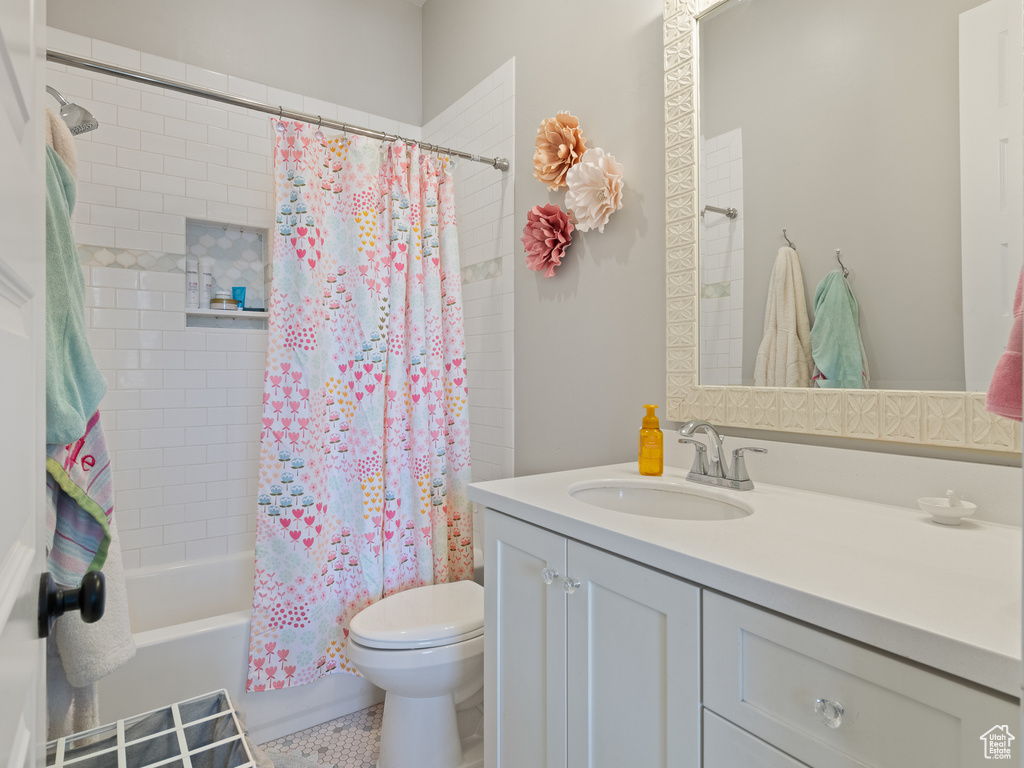 Full bathroom featuring shower / tub combo, vanity, toilet, and tile patterned flooring