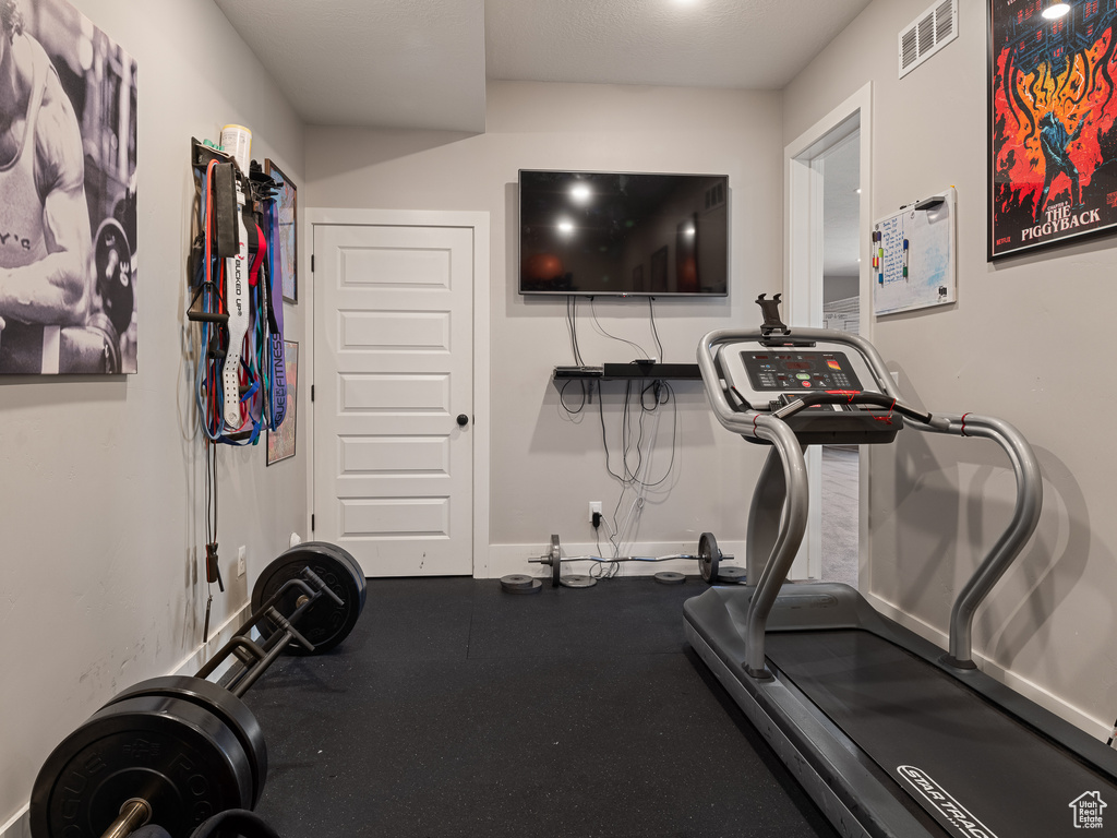 Exercise room with baseboards and visible vents