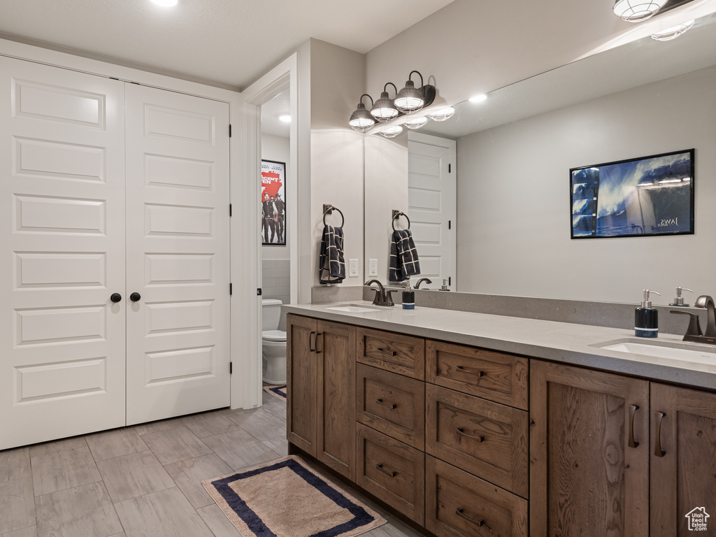 Bathroom with double vanity, toilet, and a sink