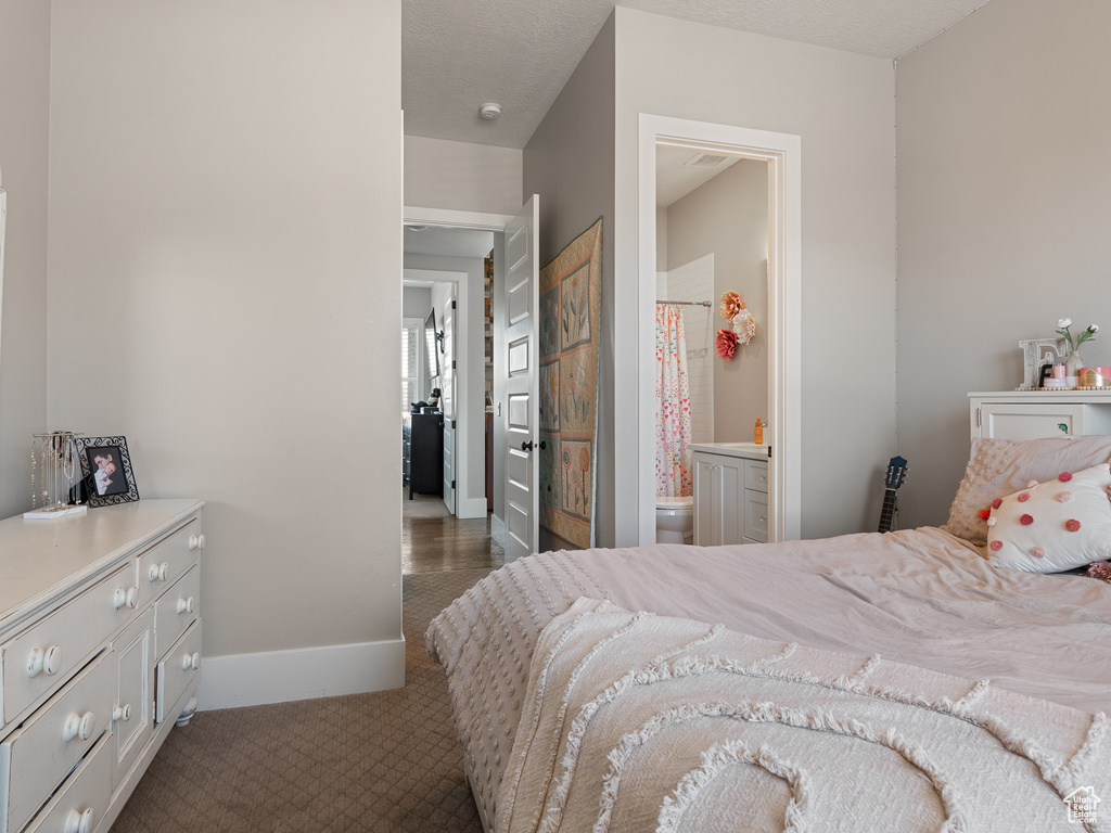 Bedroom with carpet floors, ensuite bathroom, and baseboards