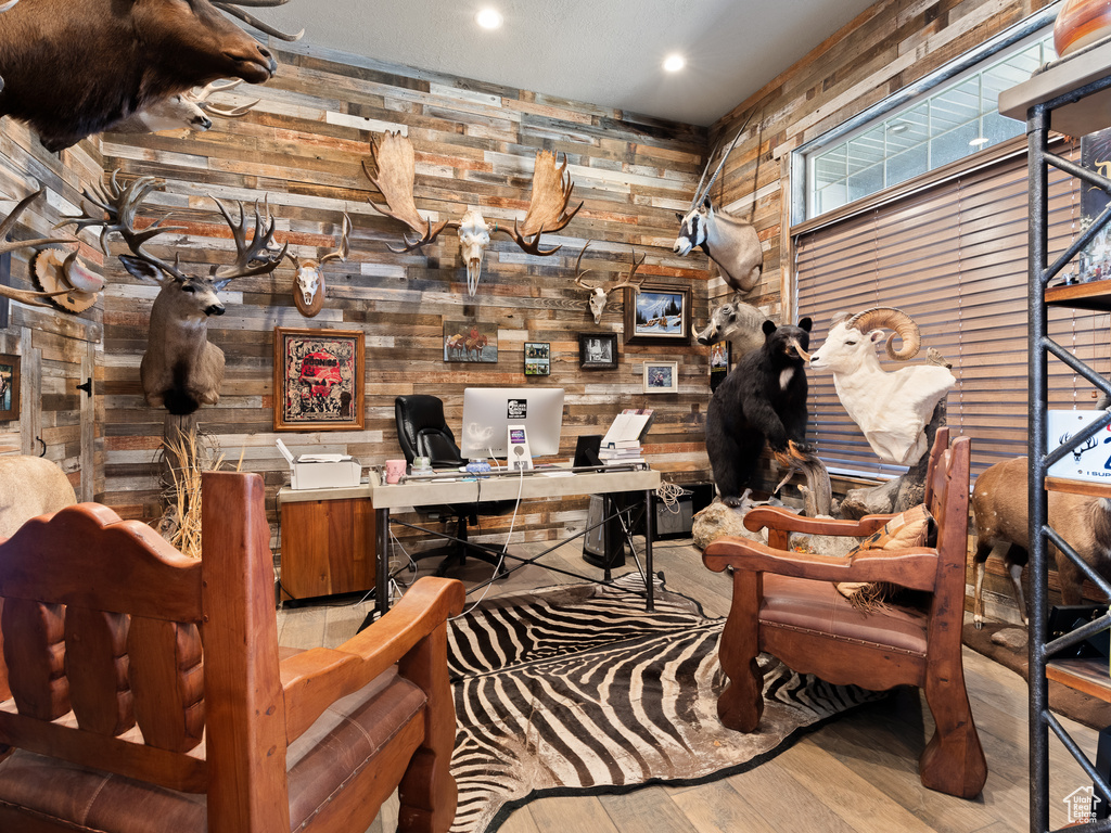 Office space with wood finished floors, wooden walls, and recessed lighting