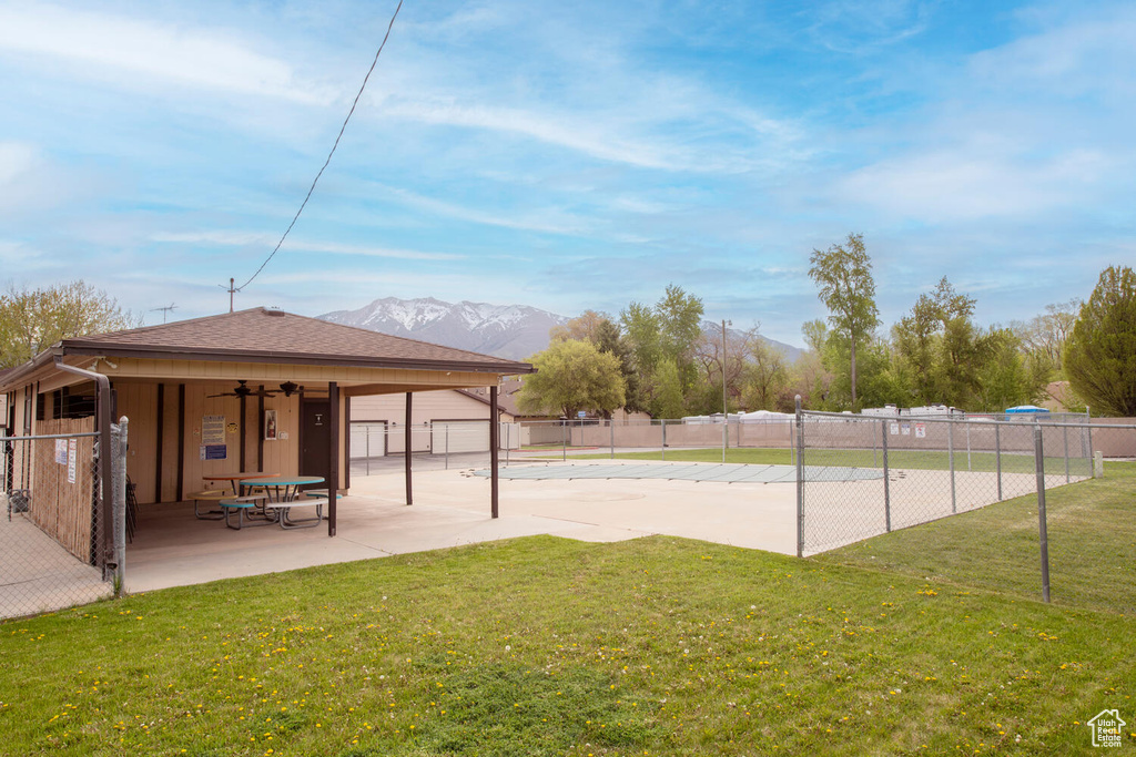 Surrounding community featuring a patio, a mountain view, fence, and a lawn