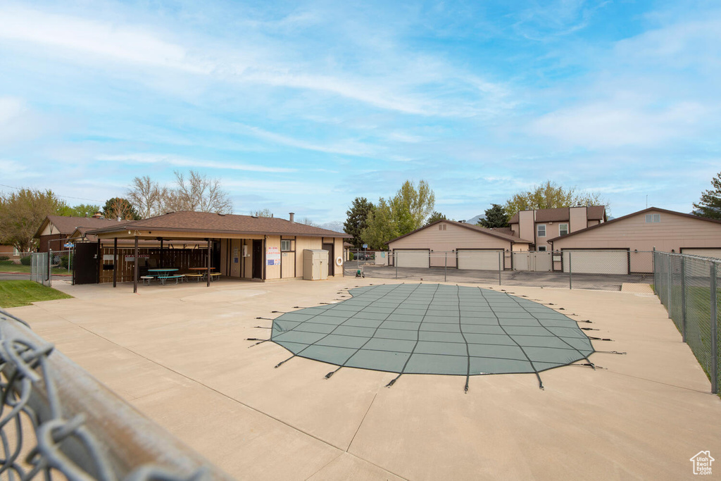 Community pool featuring fence and an outbuilding