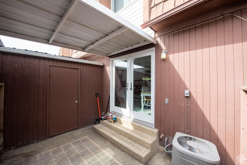 View of exterior entry featuring central AC and french doors