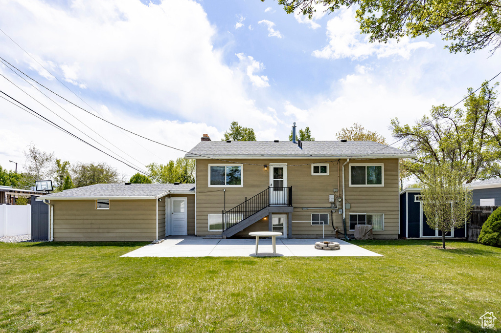 Back of property featuring an outdoor structure, a yard, a chimney, and a patio area